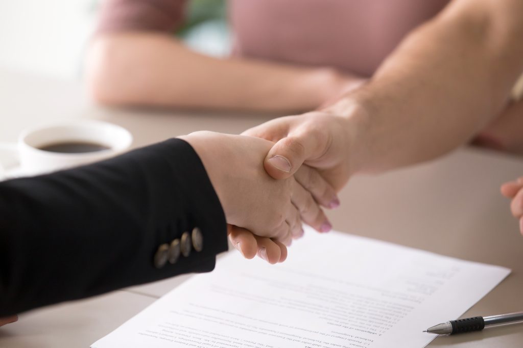 Homeowner and contractor shaking hands after signing plumbing lien waivers in Washington State.