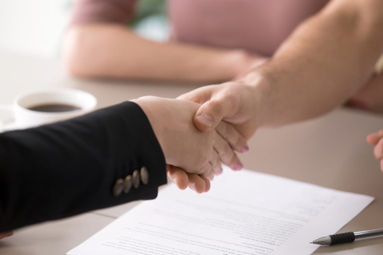 Homeowner and contractor shaking hands after signing plumbing lien waivers in Washington State.